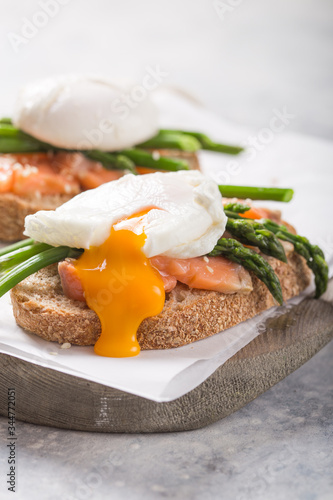 Healthy vegetarian meal. Toast,  poached egg, asparagus, salmon fish. Stone background. Clean eating Diet. Organic food.