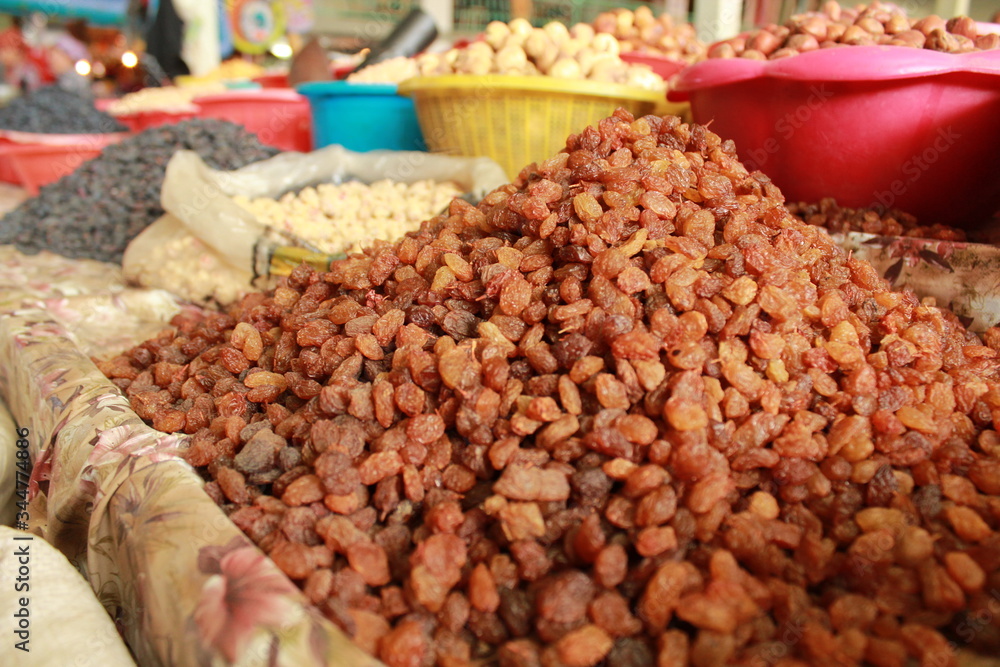 Raisins closeup in the traditional market with other food in the background Raisins closeup in the traditional market with other food in the background