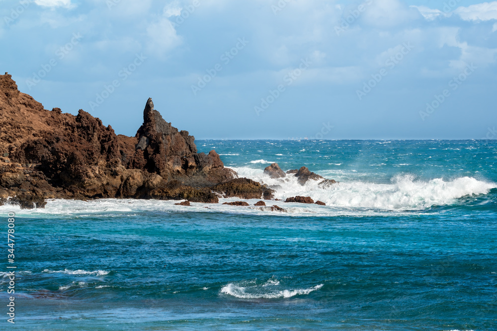 Seascape. Blue sea and rock with sea waves and beautiful blue sky.