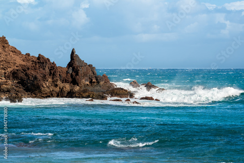 Seascape. Blue sea and rock with sea waves and beautiful blue sky.