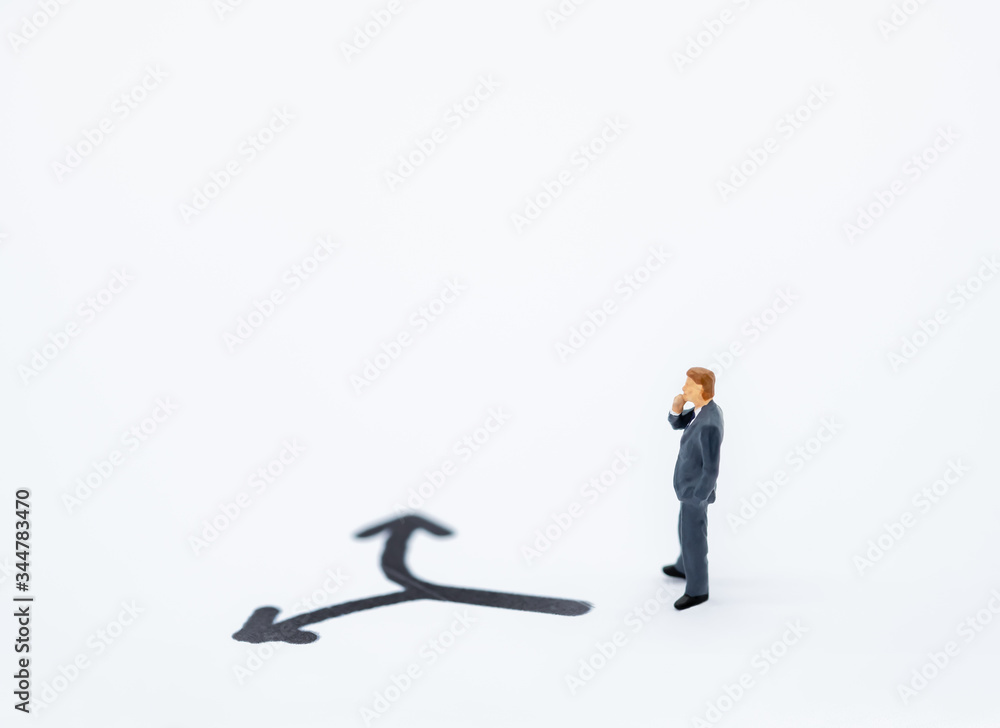 Businessman miniature people figure thinking and looking to direction left or tight arrow on white background with copy space using for business,marketing and financial concept. Businessman miniature people figure thinking and looking to direction left or tight arrow on white background with copy space using for business,marketing and financial concept.