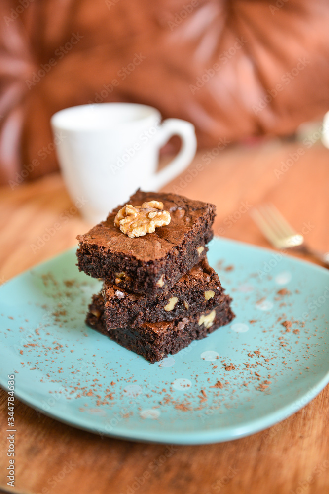 BROWNIES.A stack of chocolate brownies on a plate with wooden background homemade bakery and dessert. BROWNIES.A stack of chocolate brownies on a plate with wooden background homemade bakery and dessert.