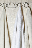 white and beige towels on a hook on the wall in the bathroom