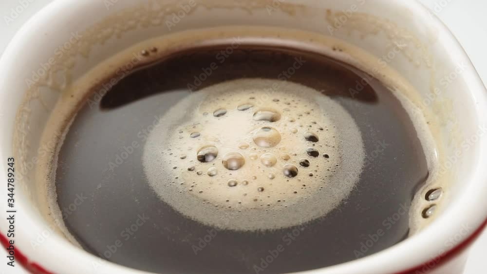 black coffee in a mug close-up macro. brown brewed coffee bubbles. black coffee in a mug close-up macro. brown brewed coffee bubbles.