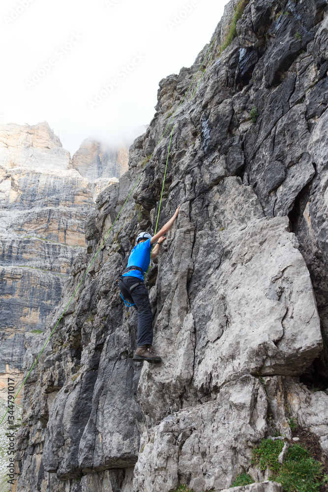 Man doing rock climbing with rope in Brenta Dolomites mountains, Italy Man doing rock climbing with rope in Brenta Dolomites mountains, Italy