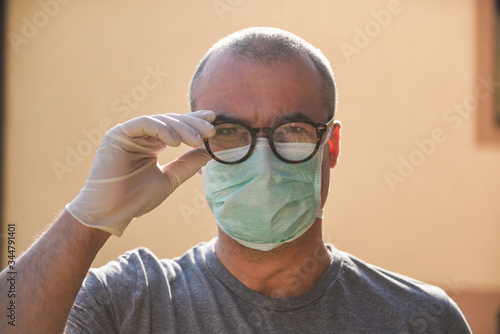 Man in the protective mask and gloveswearing a glasses photo