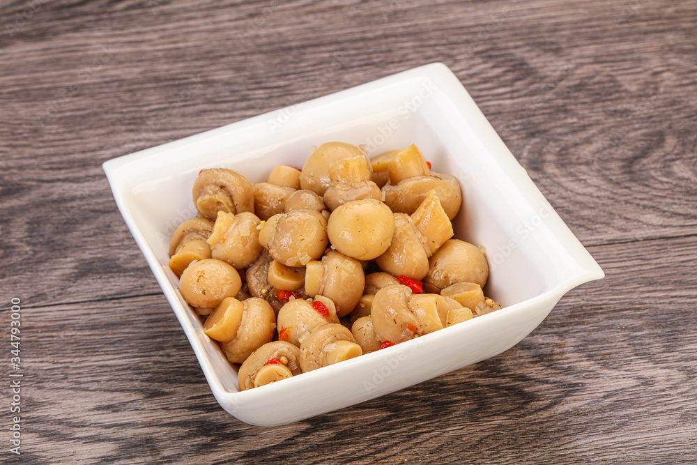 Pickled champignons in the bowl Pickled champignons in the bowl