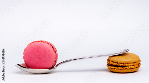 Macarons de couleurs avec petite cuillère sur fond blance photo