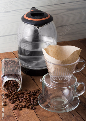 alternative brewing of coffee through a filter with a kettle on a wooden table