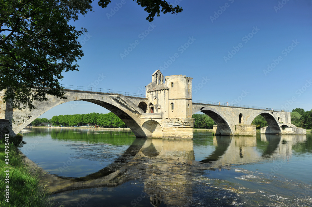 Unfinished bridge in Avignon with reflection in river Unfinished bridge in Avignon with reflection in river