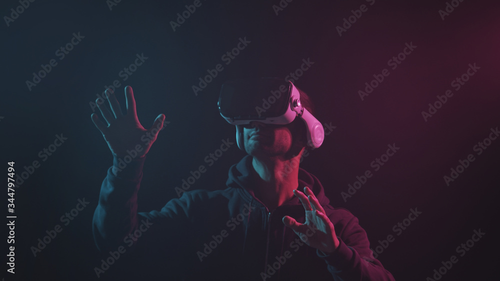 Portrait of a man in virtual reality helmet. Obscured dark face in VR goggles. Internet, darknet, gaming and cyber simulation. Portrait of a man in virtual reality helmet. Obscured dark face in VR goggles. Internet, darknet, gaming and cyber simulation.