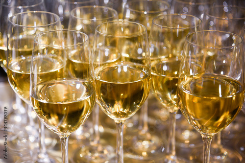 Closeup of of elegant wine glasses with white wine in a row on a table