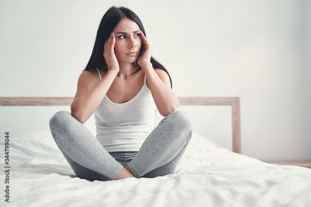Pretty brunette girl sitting on her bed Pretty brunette girl sitting on her bed