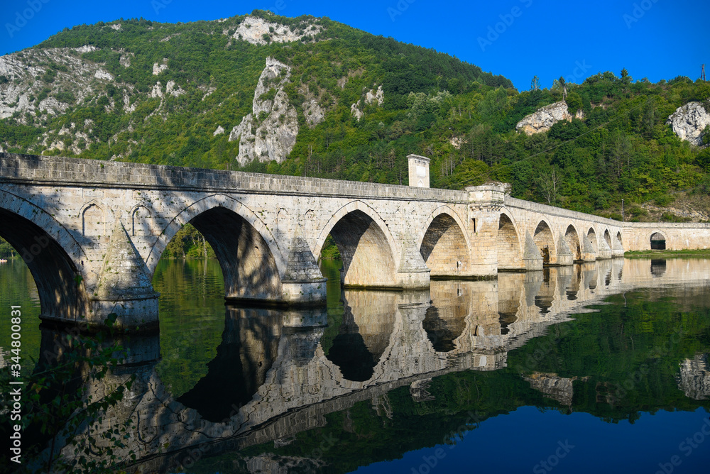 The Ottoman Mehmed Pasa Sokolovic Bridge in Visegrad, Bosnian mountains, with fantastic sky scape and river reflection. Bosnia and Herzegovina.