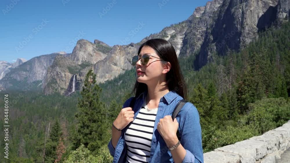 young asian woman tourist sightseeing amazing view of Yosemite National Park. bridal veil fall in mountain background. girl backpacker walking along stone bridge wear sunglasses relax in nature. young asian woman tourist sightseeing amazing view of Yosemite National Park. bridal veil fall in mountain background. girl backpacker walking along stone bridge wear sunglasses relax in nature.
