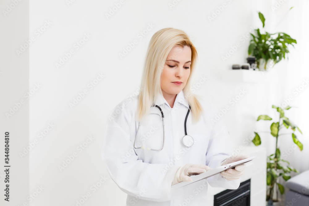 Female runette doctor using tablet, intelligent and lovely woman with the gadget and stethoscope in the white background Female runette doctor using tablet, intelligent and lovely woman with the gadget and stethoscope in the white background