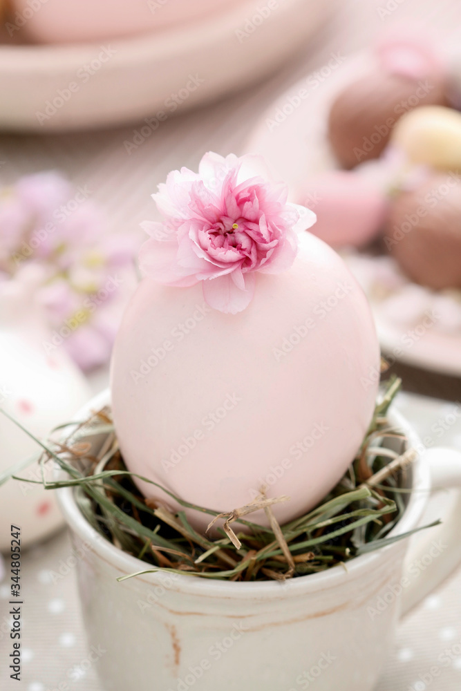 Easter egg in ceramic cup. Simple table decoration.