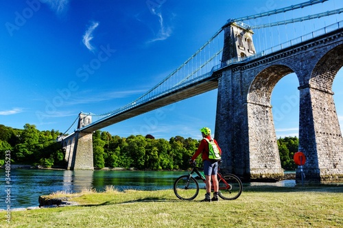 A cyclist admires the Menai Suspension bridge which links the Welsh mainland with the Isle of Anglesey