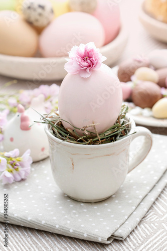 Easter egg in ceramic cup. Simple table decoration.