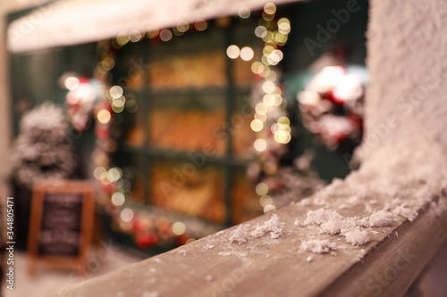 Wooden railing with snow on blurred background  closeup. Christmas celebration