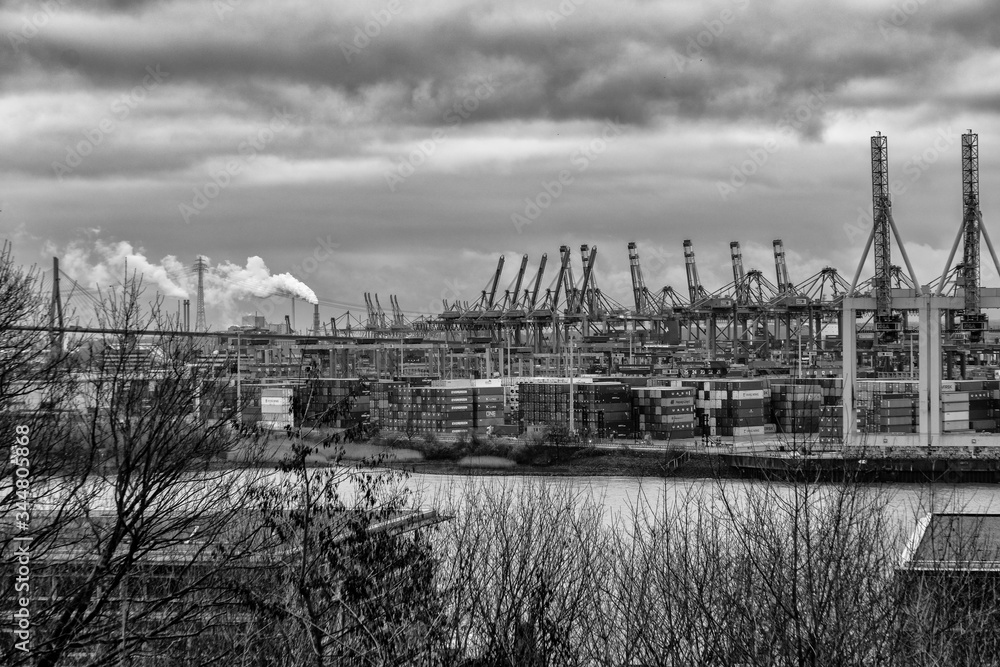 Stunning panoramic view of the Port of Hamburg with container terminal and the Köhlbrandbrücke bridge at Elbe river with a dramatic sky/clouds, Germany