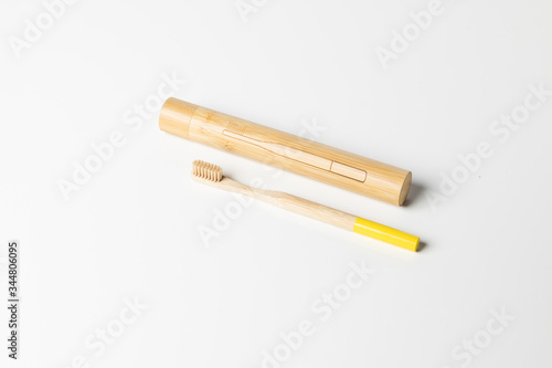 Wooden toothbrush with wooden box made of bamboo on white background.