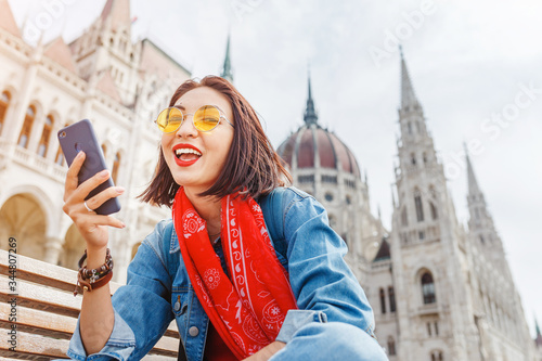 Canvas Print Asian woman chatting in smartphone by wireless internet in Budapest, Hungary