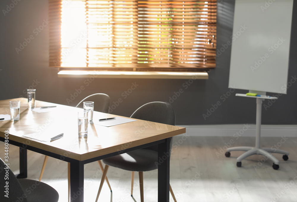Stylish office interior with wooden table and flipchart Stylish office interior with wooden table and flipchart