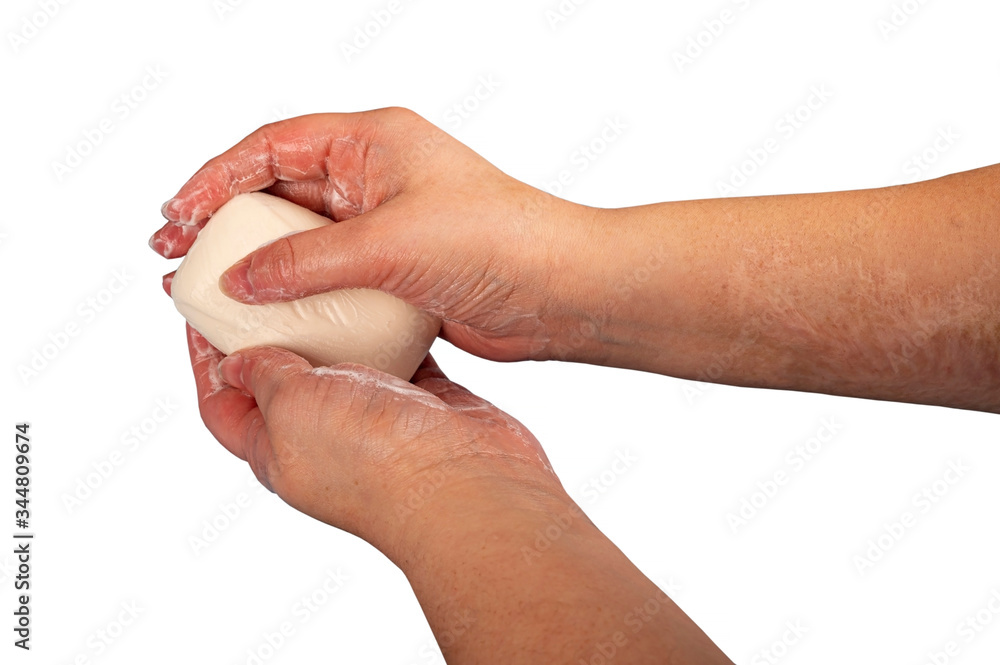Someone is soaping their hands with a piece of toilet soap. Close up. Regular hand washing with soap is a prevention of COVID-19 infection. Isolate on a white background. Someone is soaping their hands with a piece of toilet soap. Close up. Regular hand washing with soap is a prevention of COVID-19 infection. Isolate on a white background.