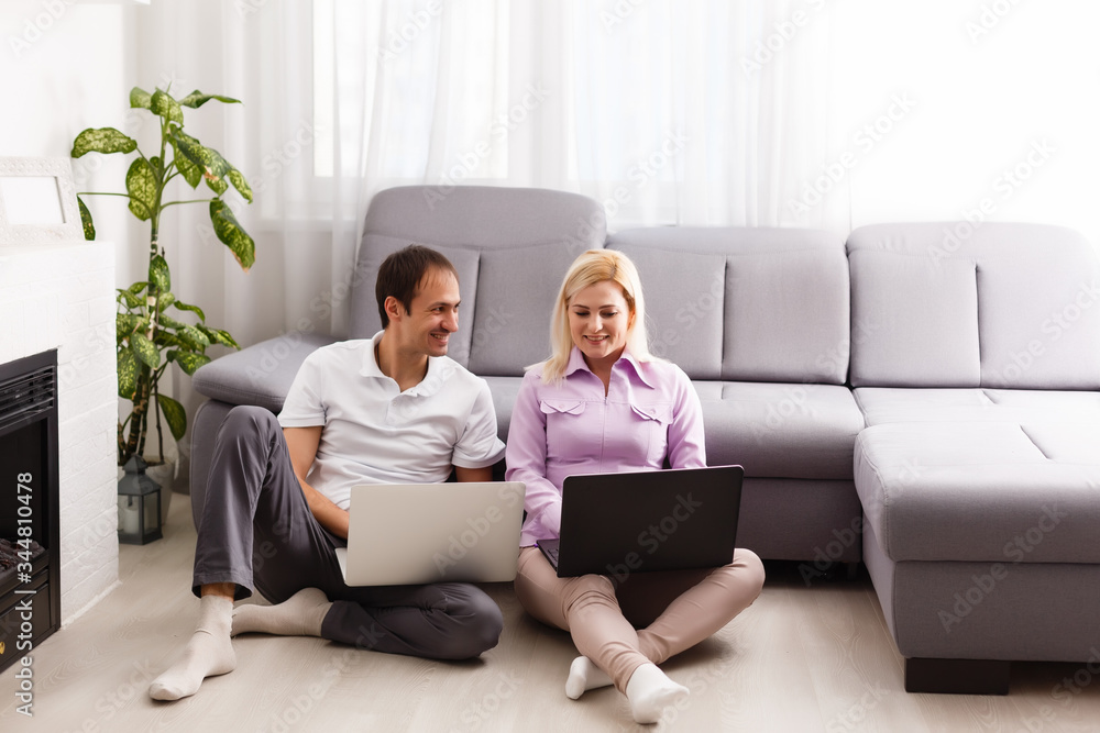Happy modern couple surfing the net and working on laptop at home Happy modern couple surfing the net and working on laptop at home