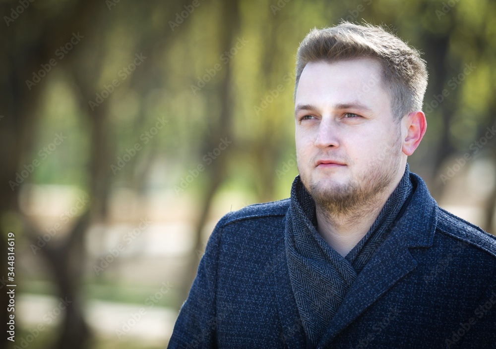 Portrait of a man in a coat in the park Portrait of a man in a coat in the park