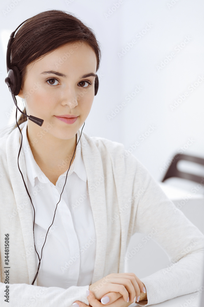 Call center. Casual dressed woman sitting in headset at customer service office. Group of operators at work. Business concept Call center. Casual dressed woman sitting in headset at customer service office. Group of operators at work. Business concept