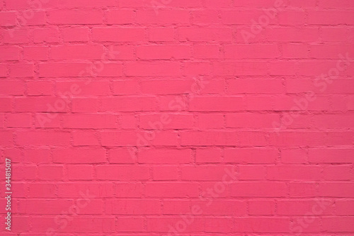 old cracked brick wall painted in pink paint