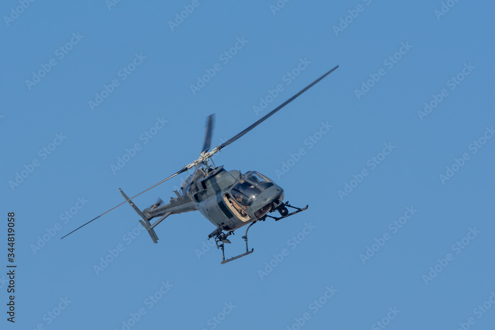 Military chopper in war flies on angle through the sky. Military concept of power, force, strength, air raid.