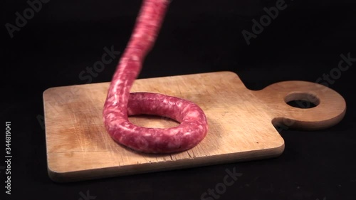 delicious fresh Italian pink pork sausage laid on a wooden cutting board on black  background