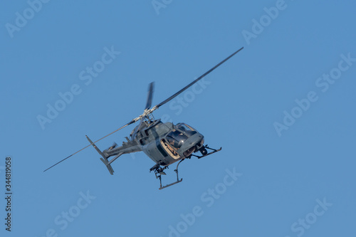 Military chopper in war flies on angle through the sky. Military concept of power, force, strength, air raid.