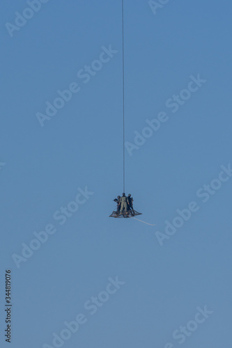 Military team in conflict resucing people by helicopter. flying through the air on a rope attached to chopper in conflict.