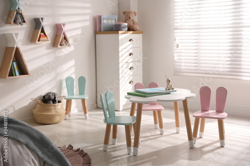 Small table and chairs with bunny ears in children s room interior