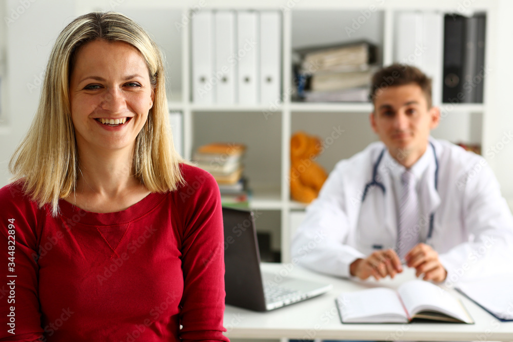 Obraz premium Satisfied happy beautiful smiling female patient with doctor at his office. High level and quality medical service, therapeutist consultation, work and career, physical, healthy lifestyle concept