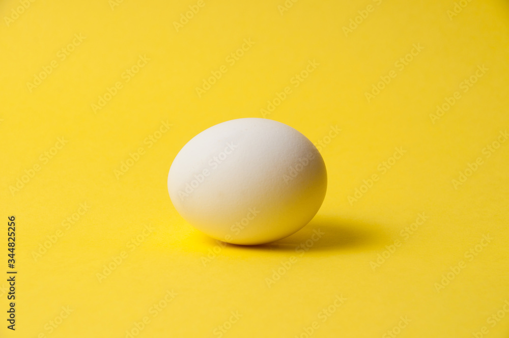 Chicken egg on a bright yellow background, copy space Chicken egg on a bright yellow background, copy space