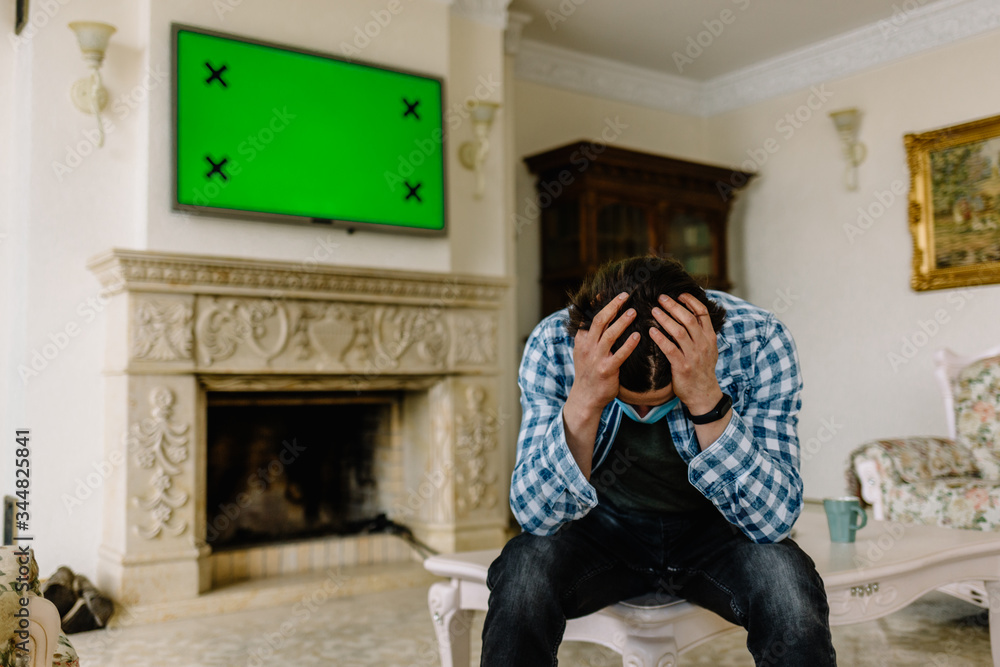 man holding his head on a background of a green screen TV