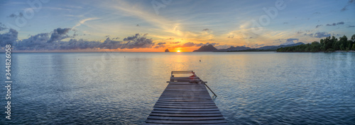 deck facing the sunrise on Exotic Antilles beach with palm tree on the Martinique Tropical beach at sunrise photo