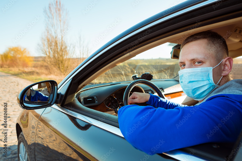 Man in the medical mask in car. coronavirus, disease, infection, quarantine, covid-19 Man in the medical mask in car. coronavirus, disease, infection, quarantine, covid-19