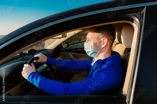 Man in the medical mask in car. coronavirus, disease, infection, quarantine, covid-19