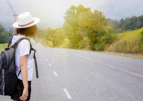 The girl carrying a backpack standing on the road