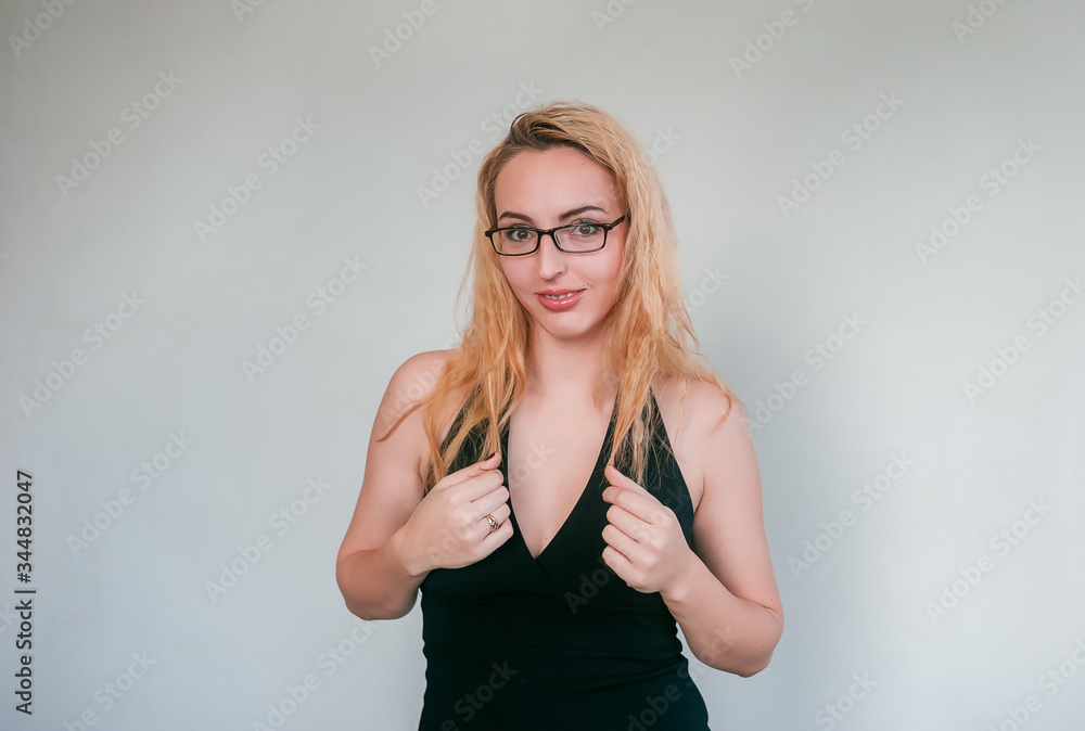 Playful smile of a young woman with blond hair. Model on ahyt gray wall. Playful smile of a young woman with blond hair. Model on ahyt gray wall.