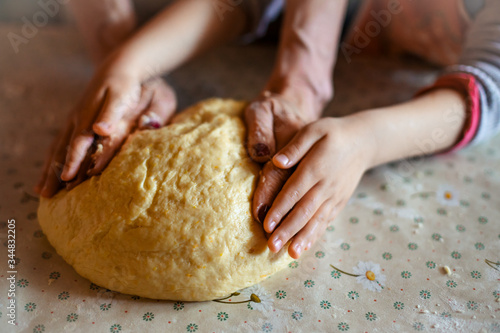 Child girl help mother to preparing bread. Hands kneads the dough. Mother's day concept