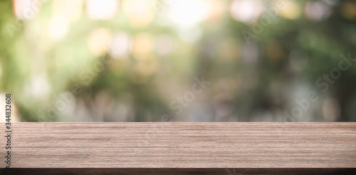 Empty wooden table top and green nature blur background for display product.
