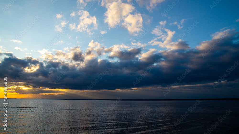 Sunset on the seashore, beach, dramatic clouds.