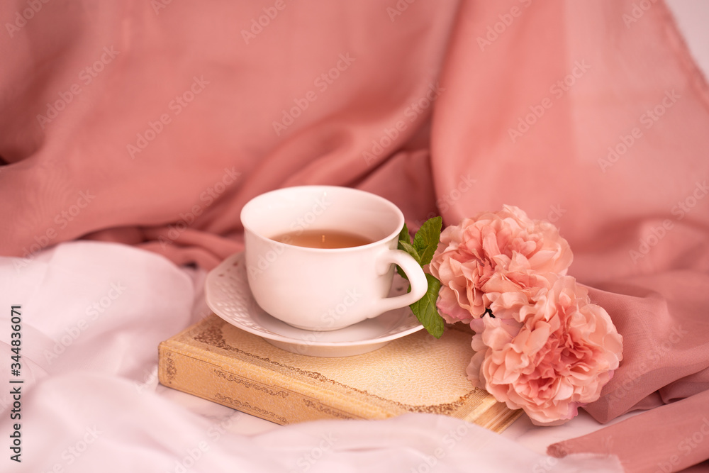 Pausa relax con libro, tè caldo e peonie rosa Pausa relax con libro, tè caldo e peonie rosa